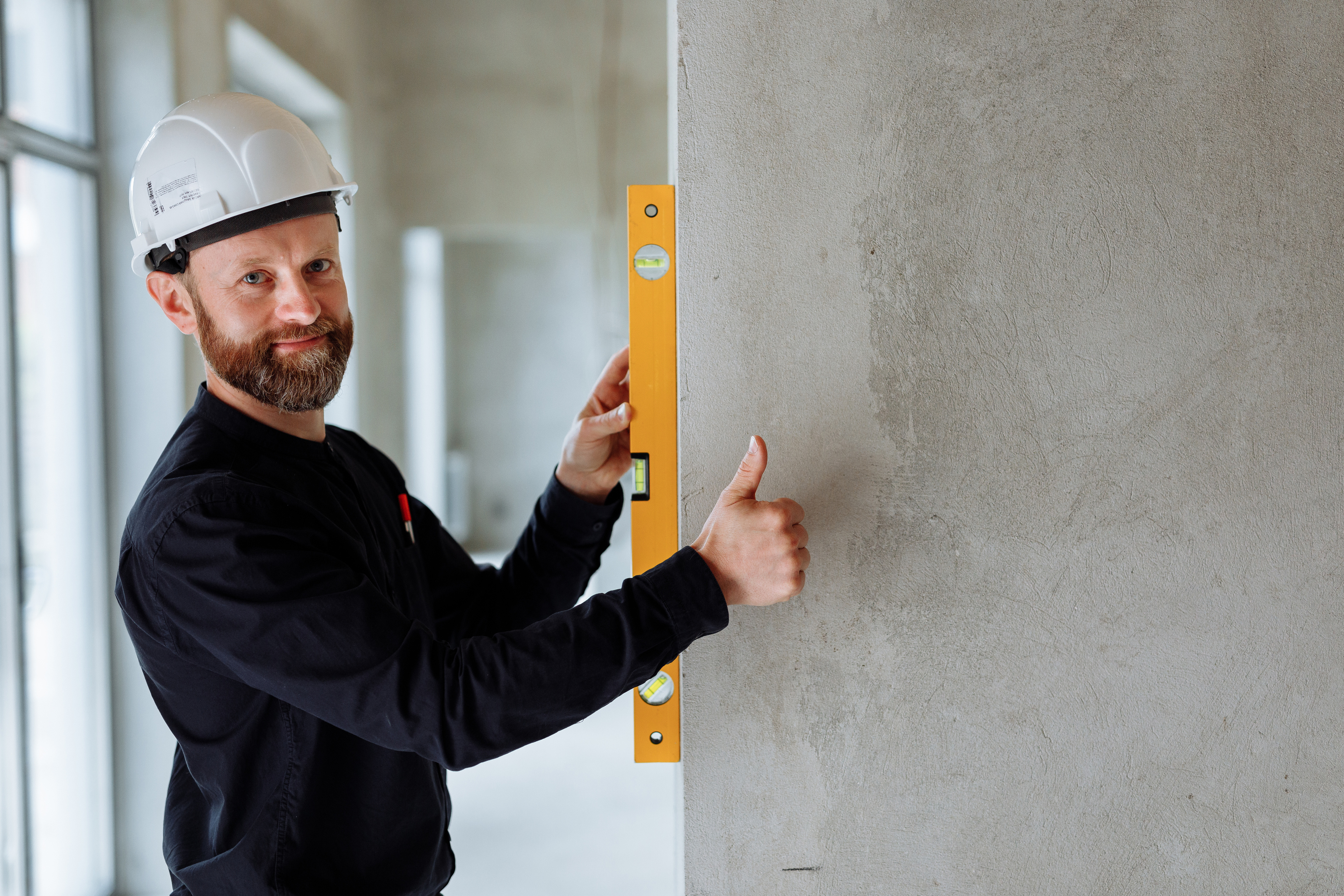 Bearded Man Holding a Yellow Spirit Level 